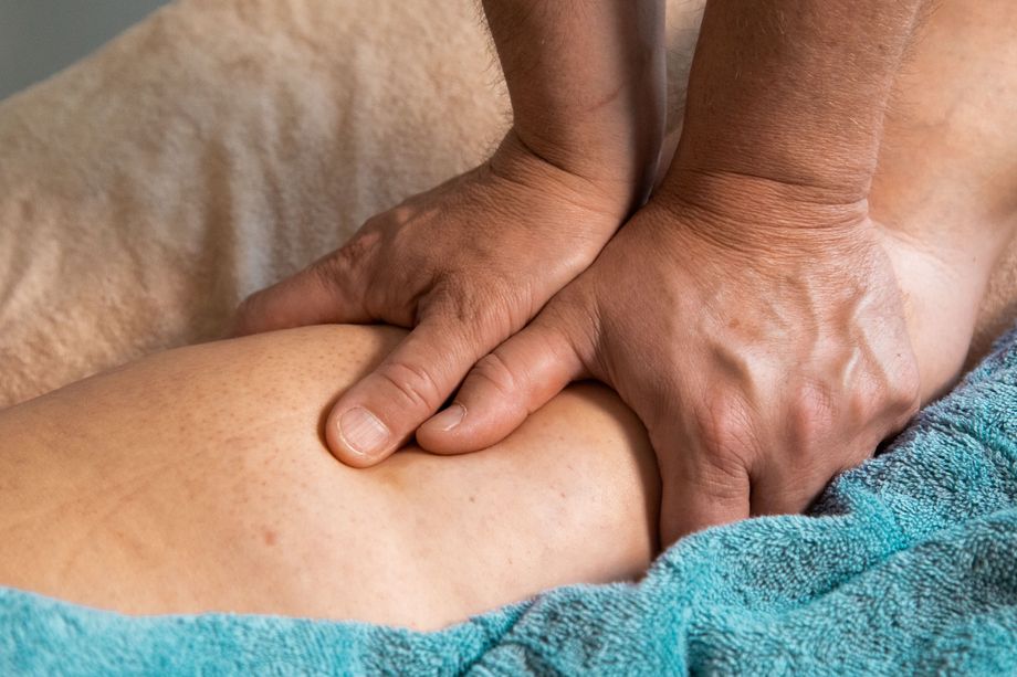 Costa de uma pessoa sendo massageada com as mãos
